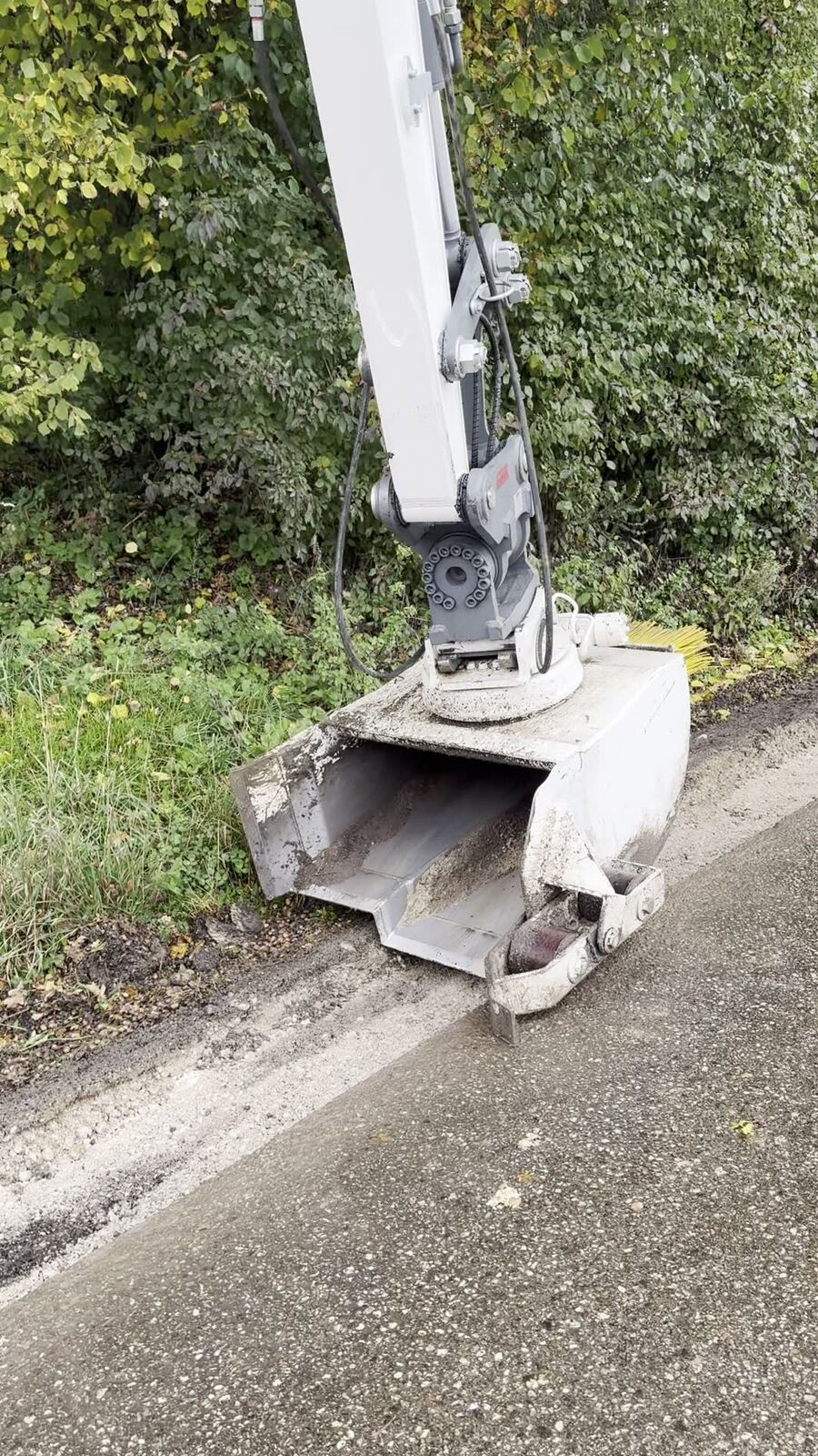 Bagger schneidet die Asphaltkante für den Bankettbau an